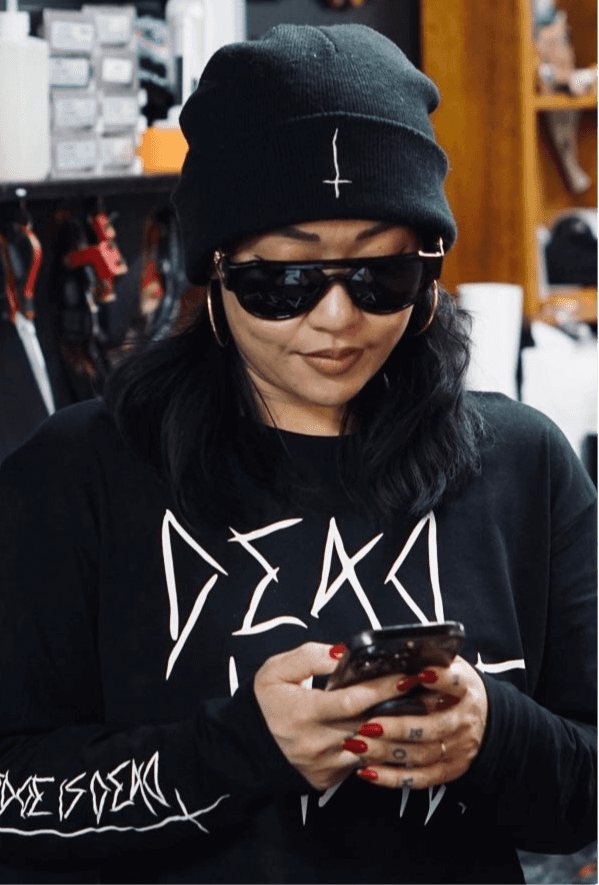 Black tight knit beanie with upside down white crossed embroidered on the front cuff