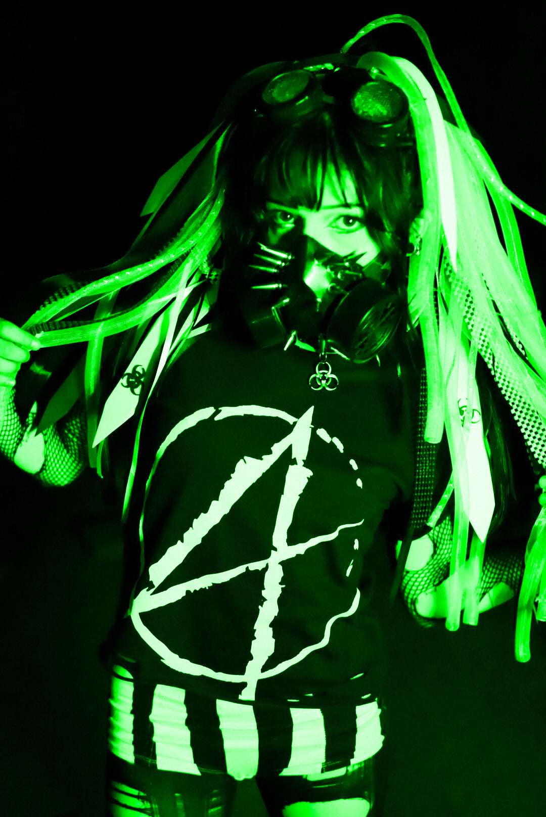 Cybergoth girl in post apocalyptic scene, wearing a black cropped tshirt with a big white A (for anarchy) print on the front