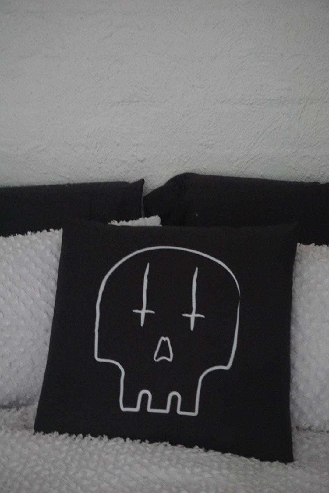 Reversible black cushion with white skull print with inverted crosses for eyes
