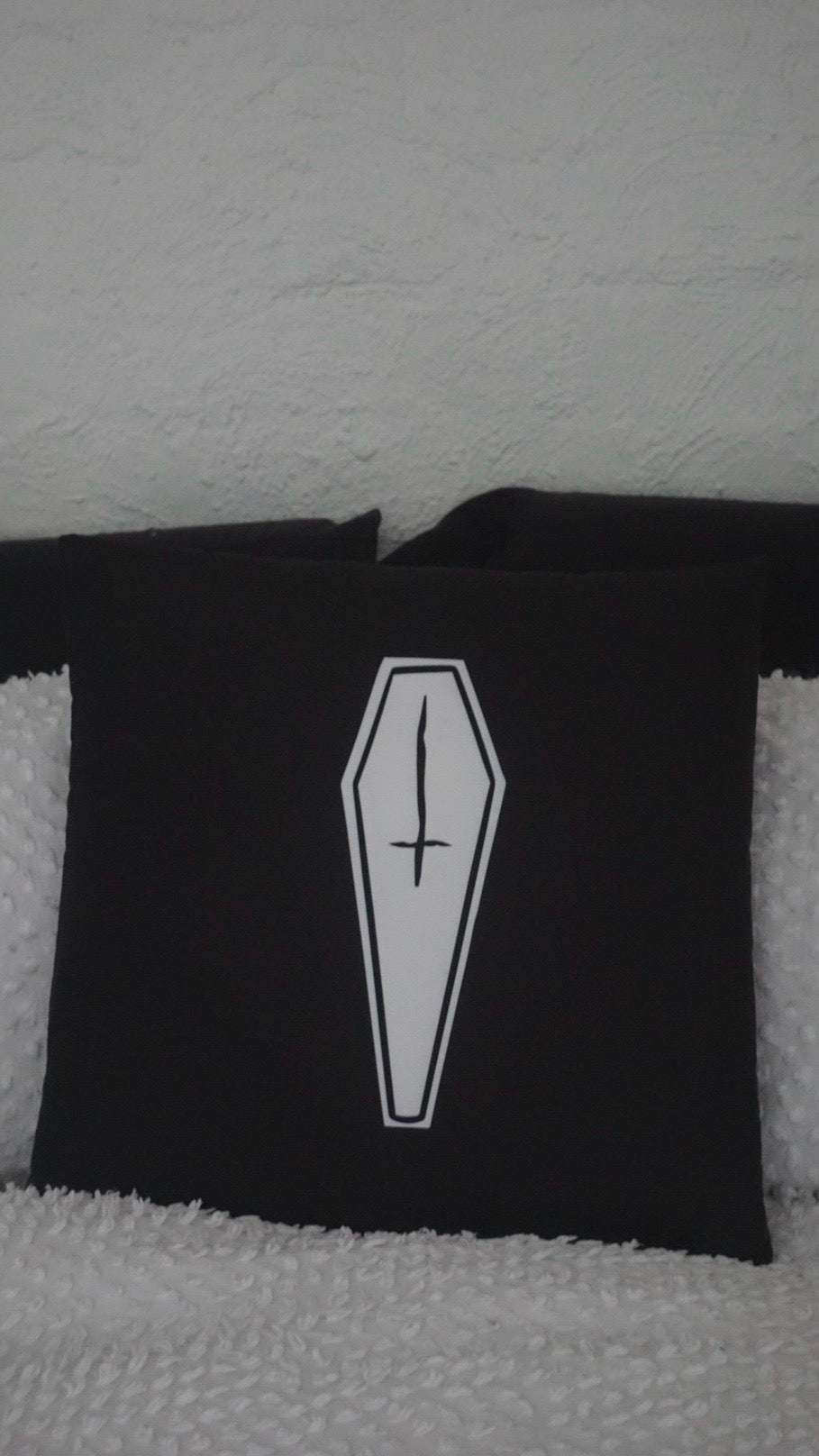 Reversible black cushion with white coffin print with inverted crosses