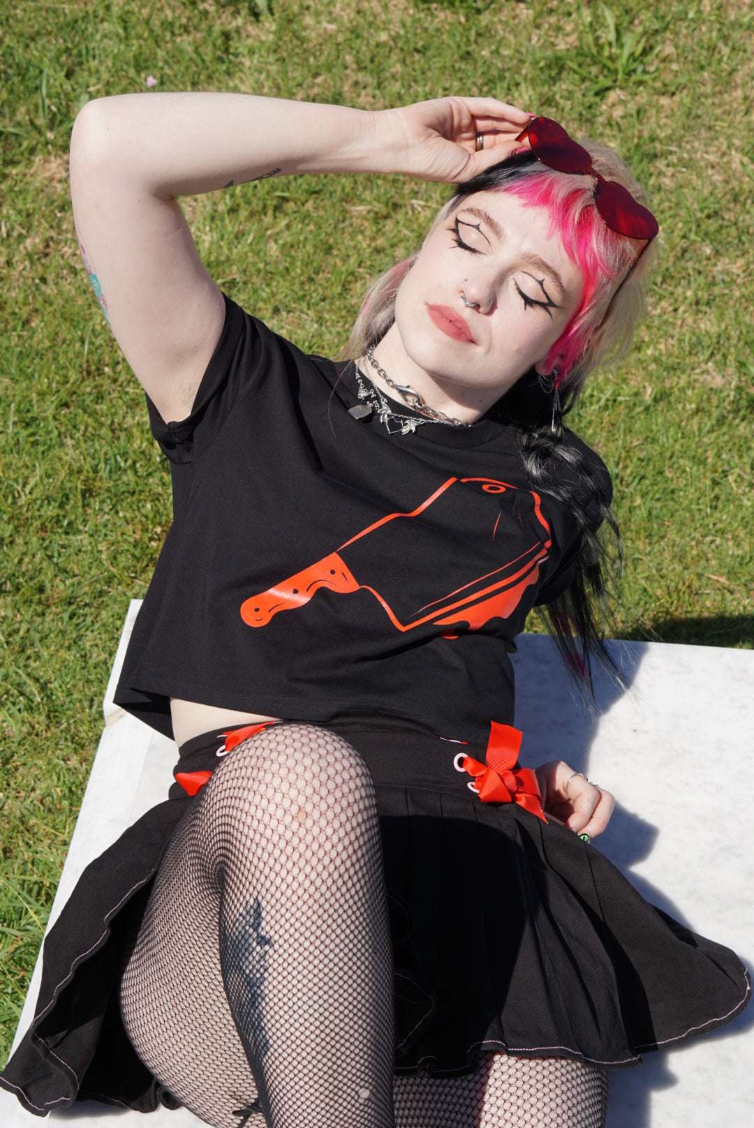 Model wearing Off with their Heads Cropped Tee with red cleaver print, paired with gothic accessories and black mini skirt for edgy summer goth outfit.