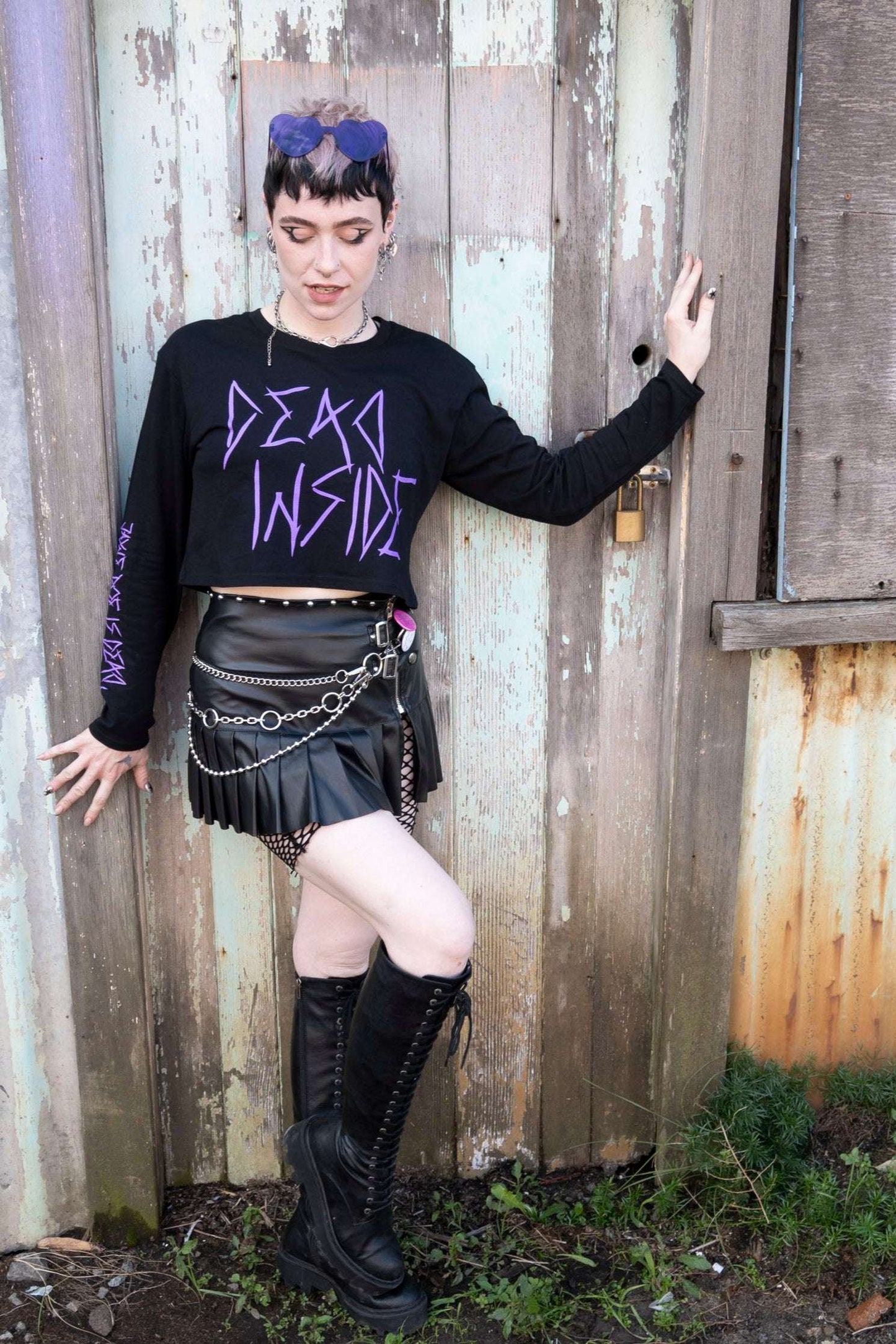 Emo girl wearing a long sleeve black cropped tshirt with the words dead inside printed on the front in purple gothic font. The arm has a jayne doe is dead