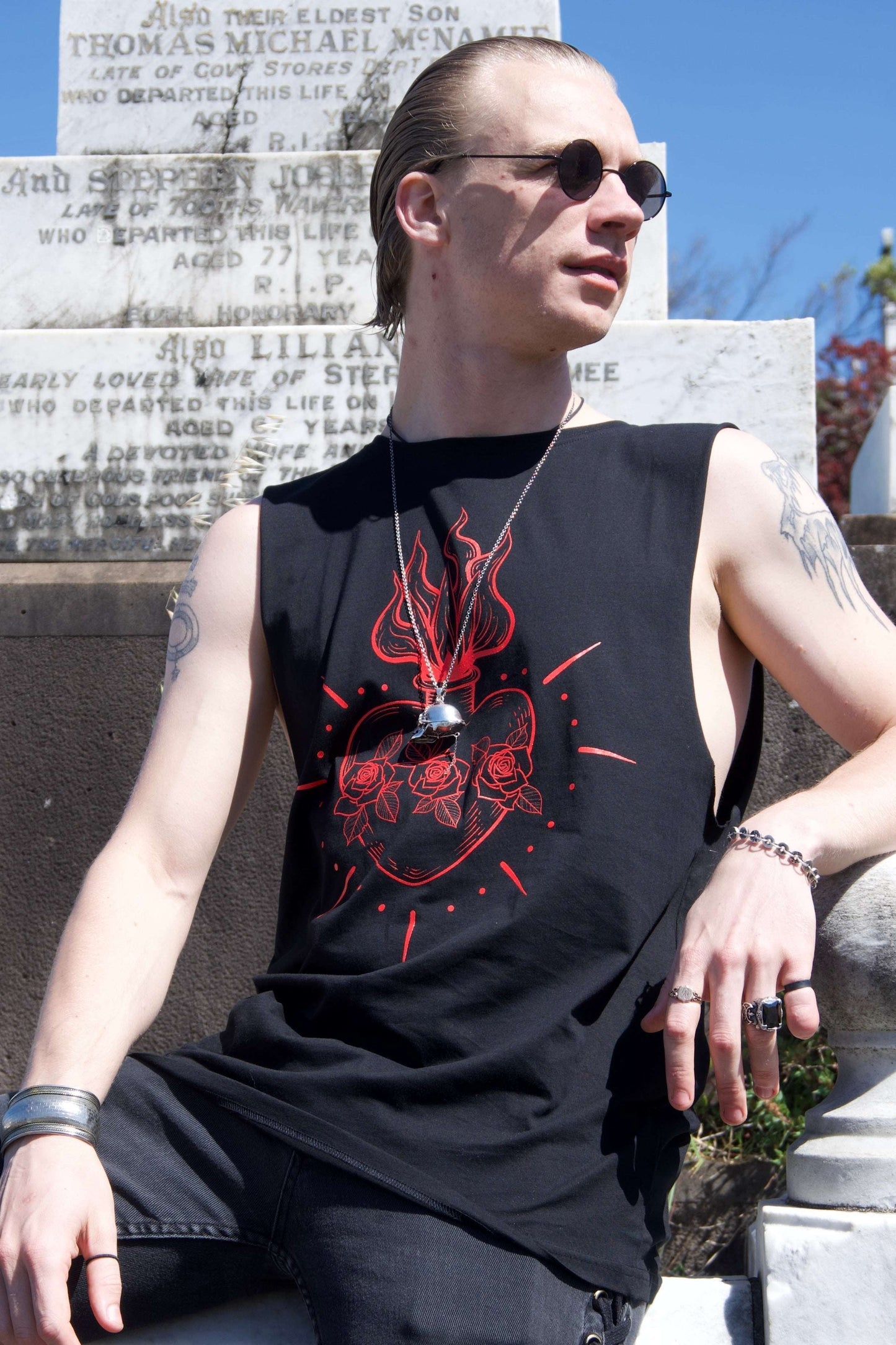 Queen of Hearts Tank/Dress styled as a tank top with red sacred heart tattoo graphic, worn by male model in gothic streetwear setting.