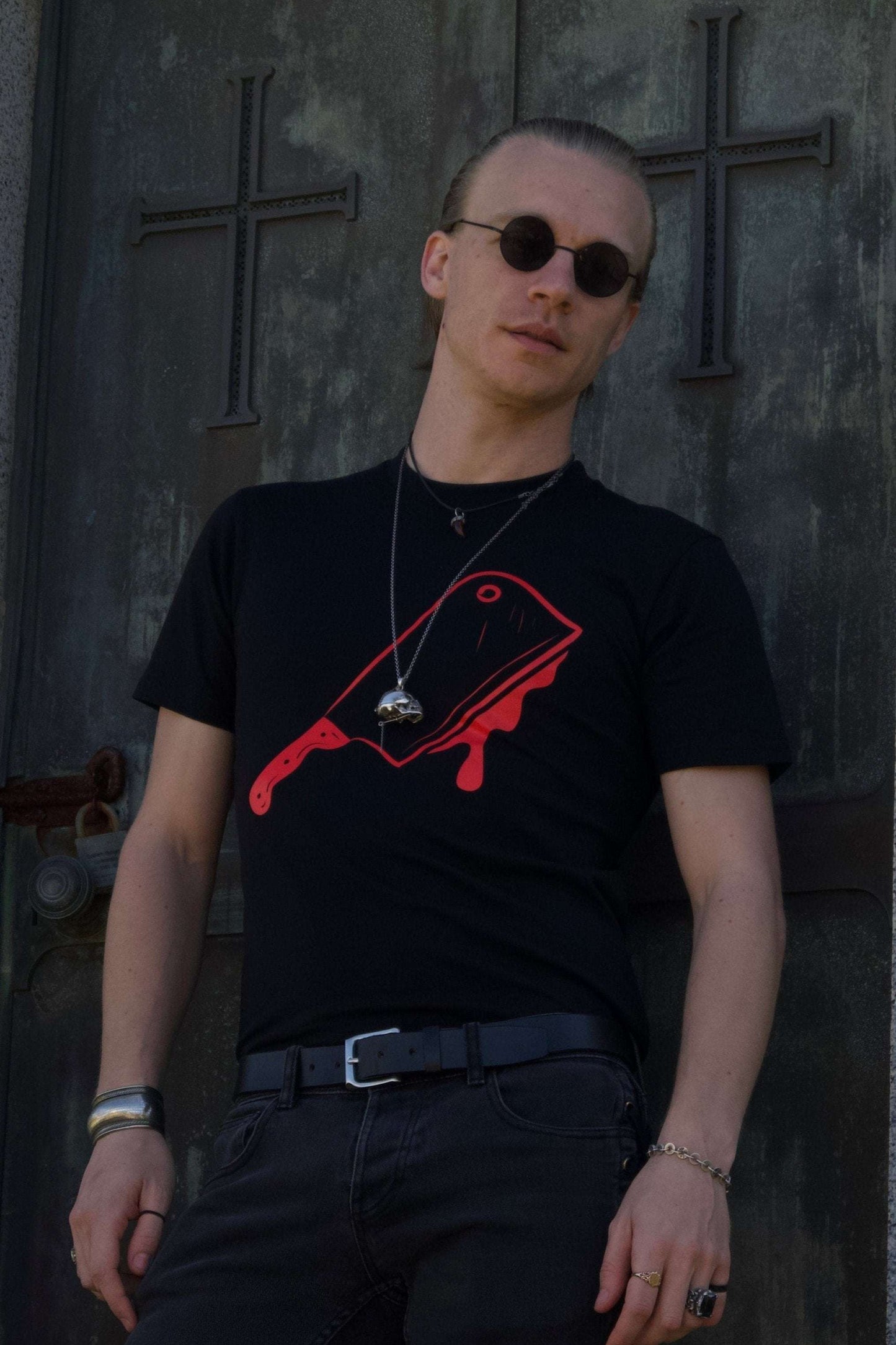 Off with their Heads Tee in black featuring bold red cleaver graphic on front, styled with dark jeans and accessories for a gothic streetwear look.