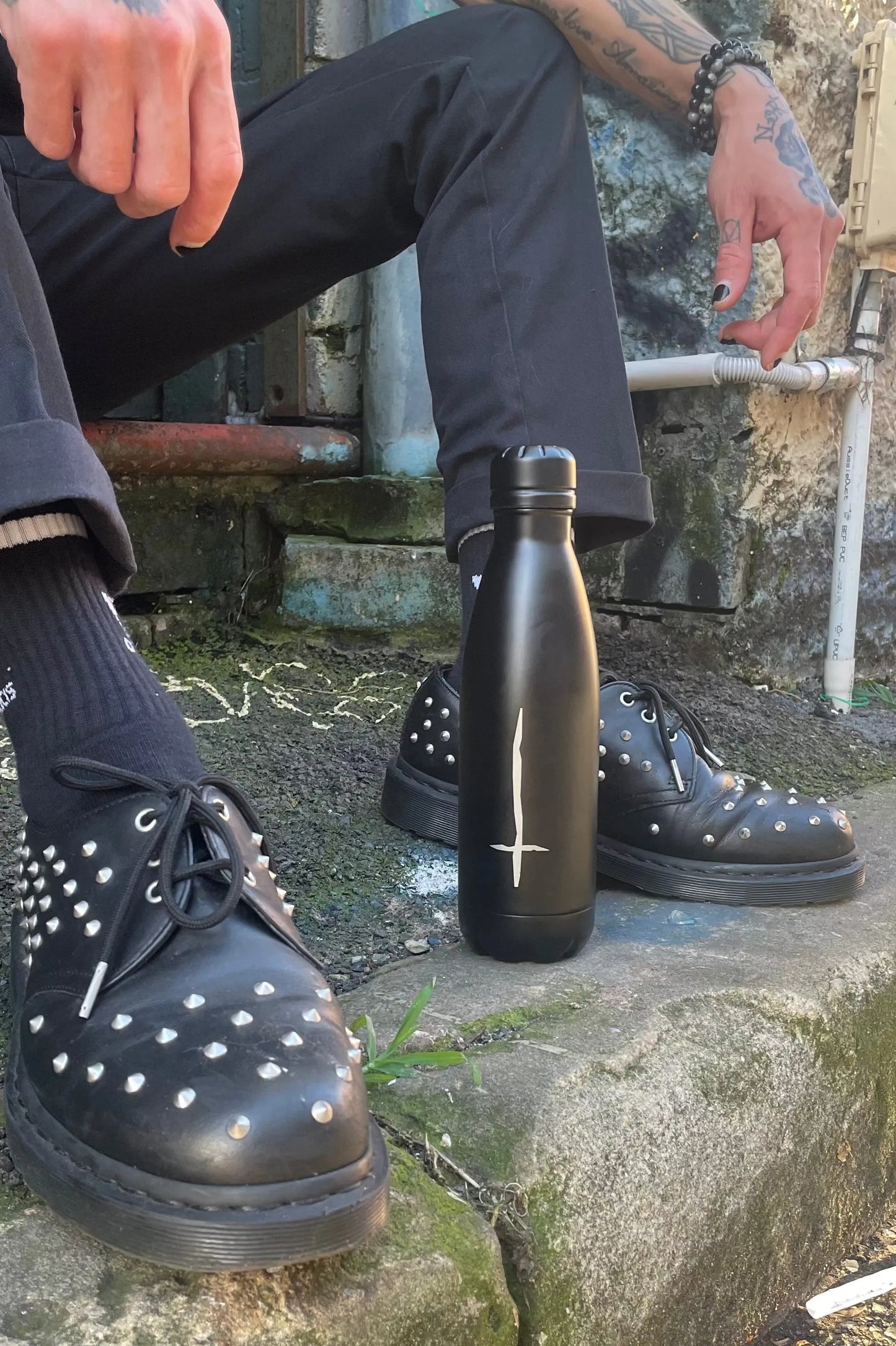 Matte black water bottle with silver upside down crossed etched into the side