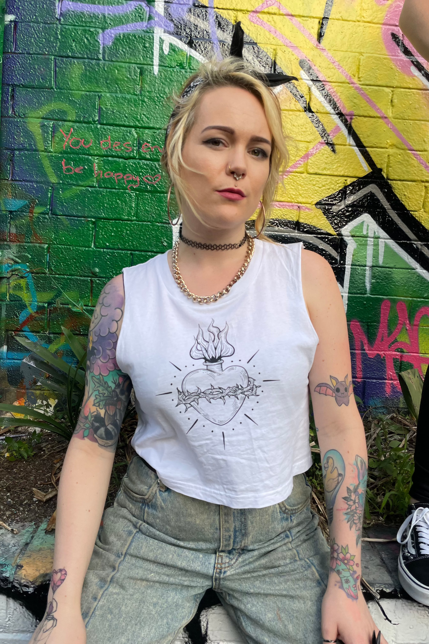 Alt woman with white cropped tank top with black sacred heart print on in it