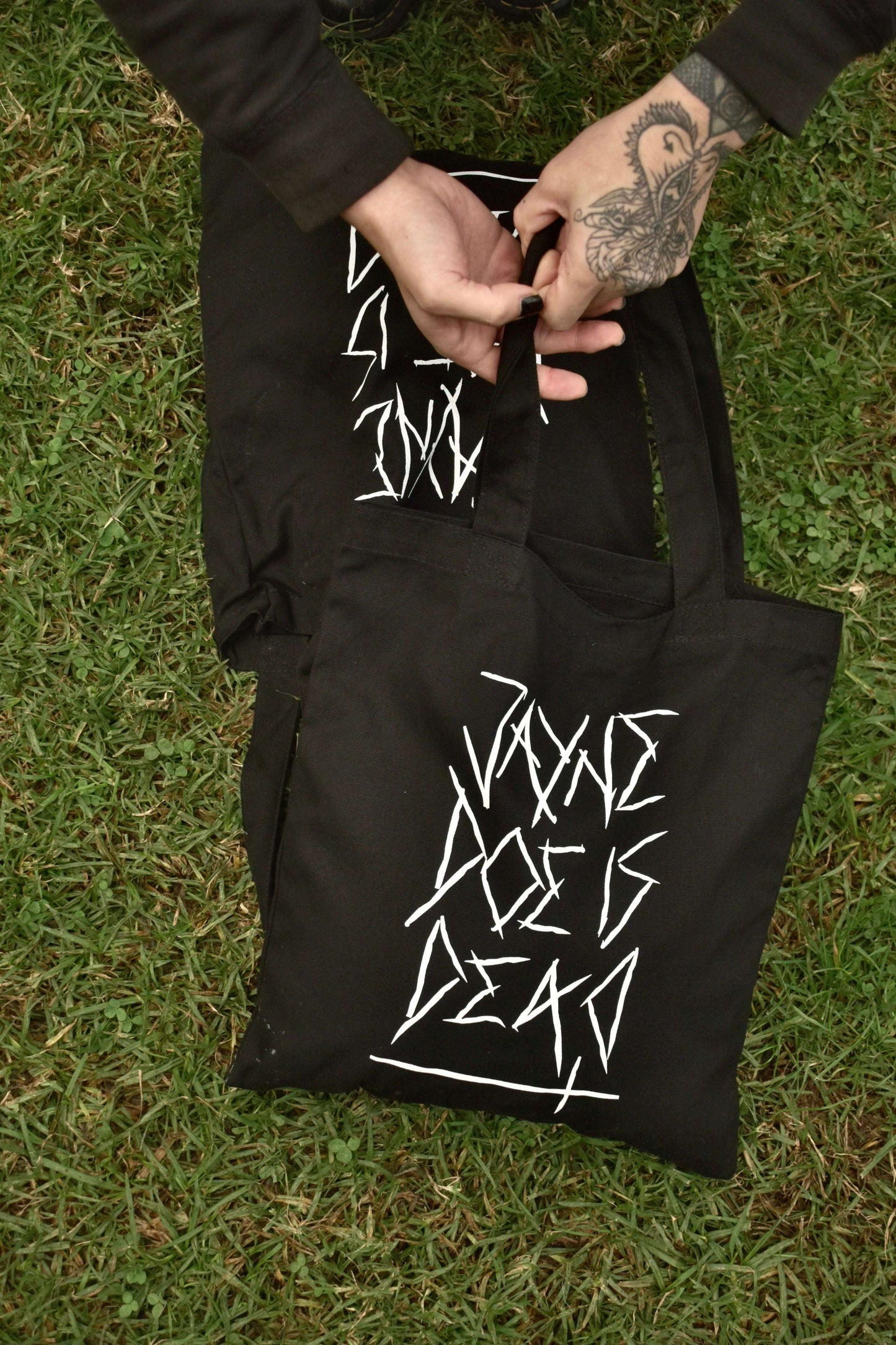 Black premium quality tote bag with jayne doe is dead printed in white on the front in a gothic / emo style