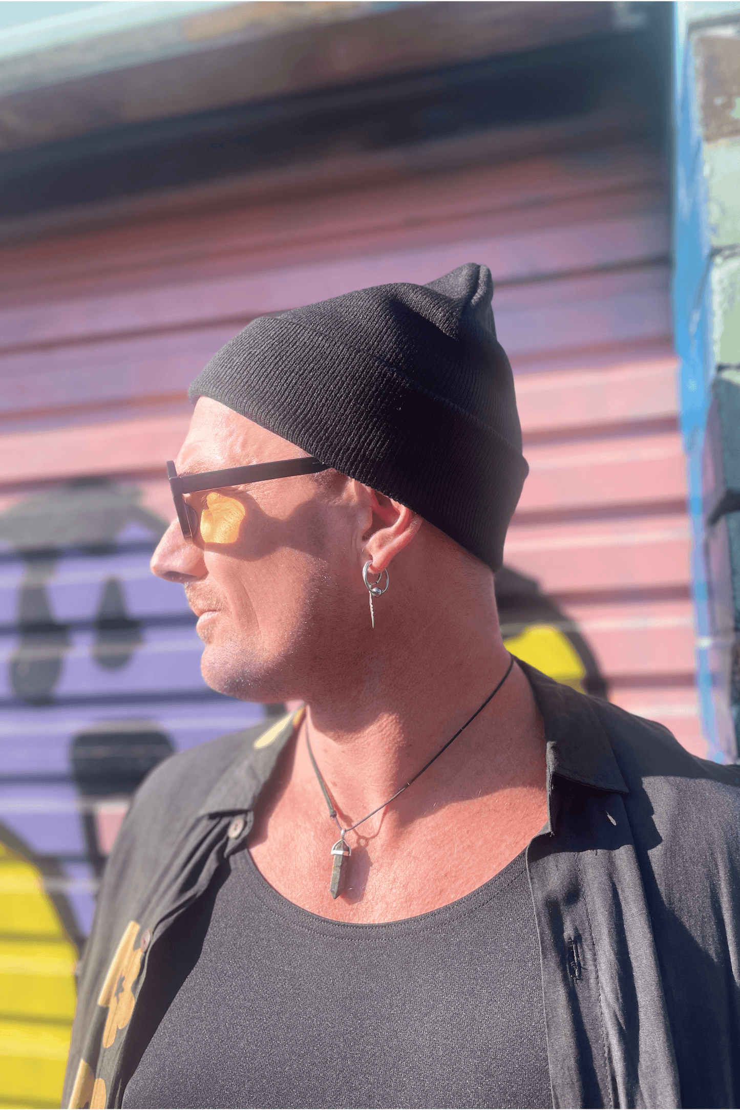 Black tight knit beanie with upside down white crossed embroidered on the front cuff