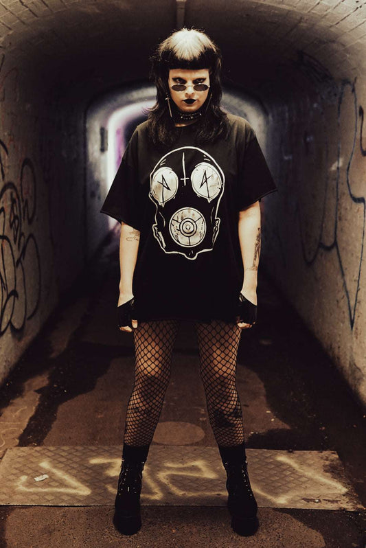 Post apocalyptic style Drone Regular Raw Tee - Desolate, featuring bold white graphic gas mask print worn by model in fishnets and platform boots in urban tunnel.