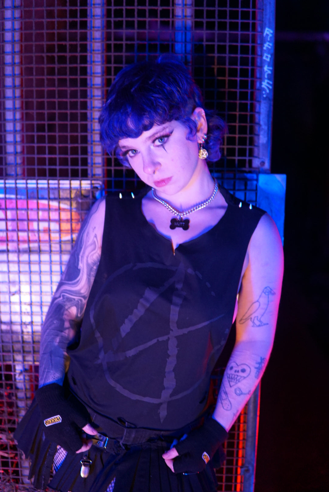 Non binary person wearing a size small Anarchy Cropped Tank with a goth black A print on the front