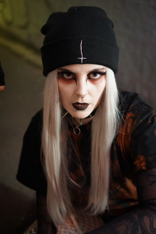 Sinner Beanie in black with inverted cross embroidery, styled in a gothic streetwear look. Tight knit, relaxed fit, perfect to finish your fit